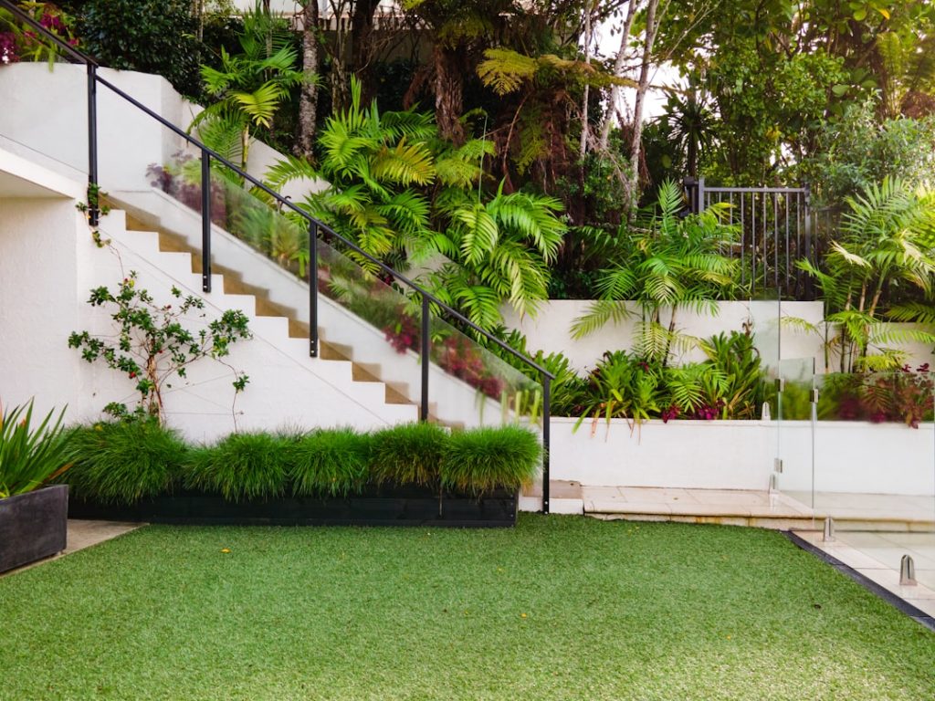a-white-house-with-a-green-lawn-and-stairs-o7asohdv9e